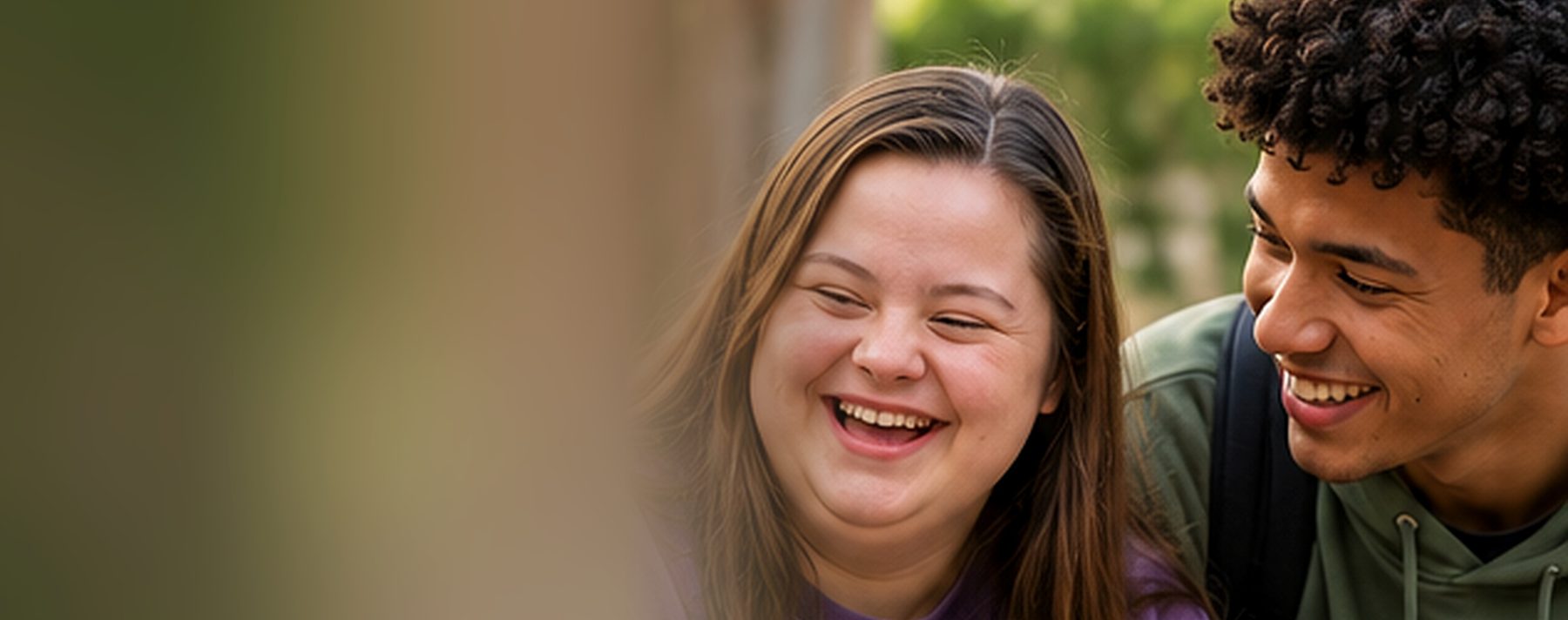 Two young adults laughing together outdoors